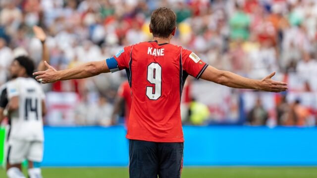Harry Kane in England's red kit with arms outstretched