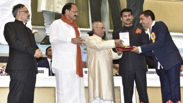 Producer Dil Raju receiving an award from former President Pranab Mukherjee on stage
