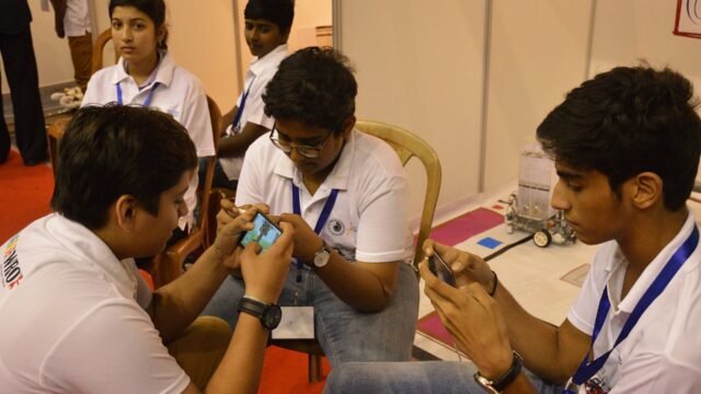 Students playing a mobile game on smartphones