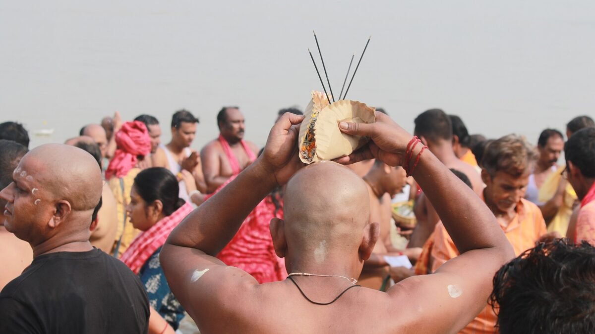 Devotees performing tarpan at a riverbank on Mahalaya