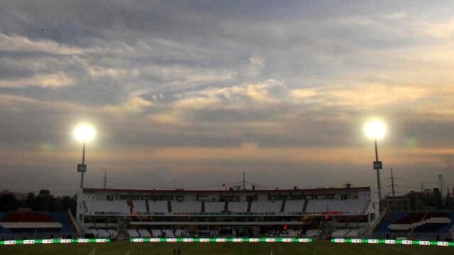 Rawalpindi Cricket Stadium with floodlights on at dusk